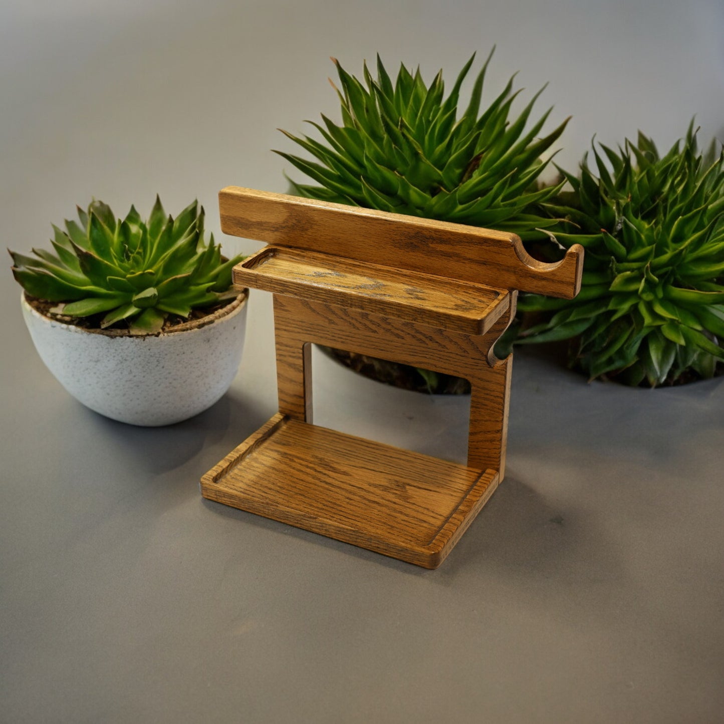 An empty CPAP Stand made by Custom Cave Works.  The stand is next to some greens and includes catch-all trays to keep your nightstand organized.  The stand is sold oak wood that has a satin finish.  